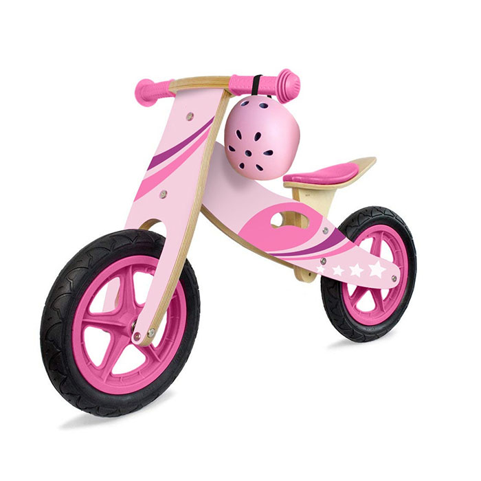 A beautiful wooden balance bike next to a standard metal one, shown in a park setting