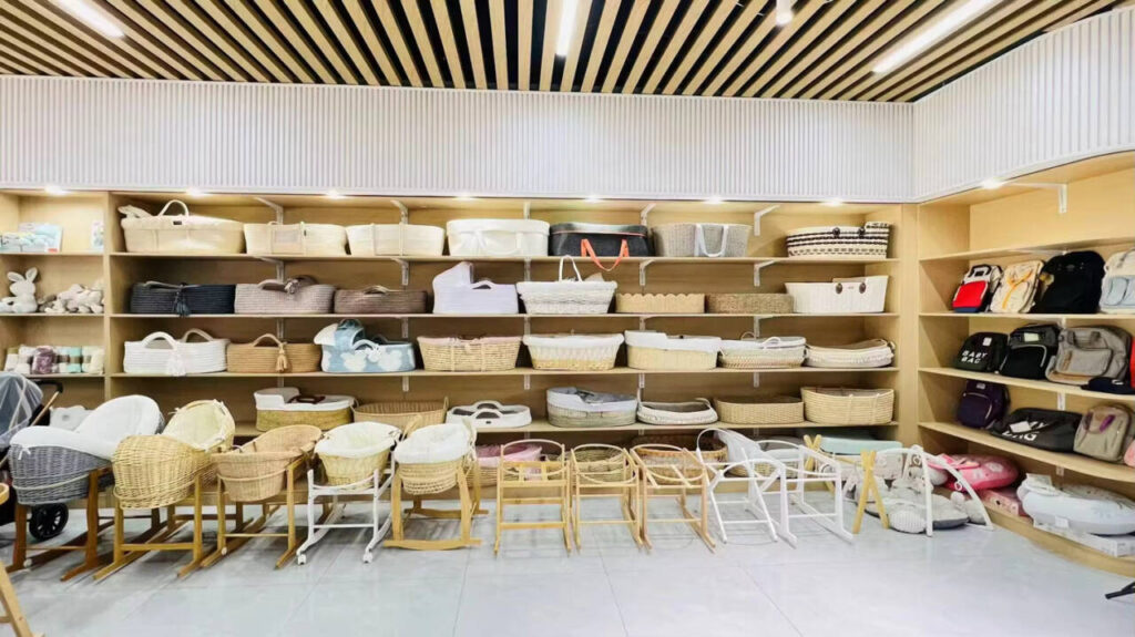 A parent carefully inspecting the mattress fit and handle strength of a Moses basket in a store