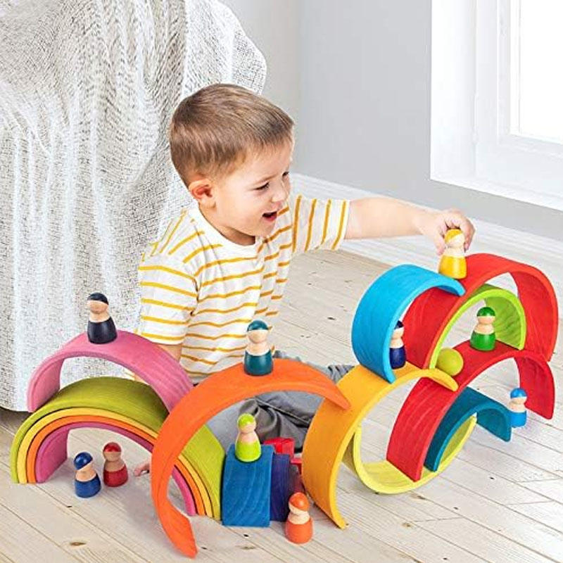 A child's hands holding and feeling a smooth, curved wooden grasping toy.