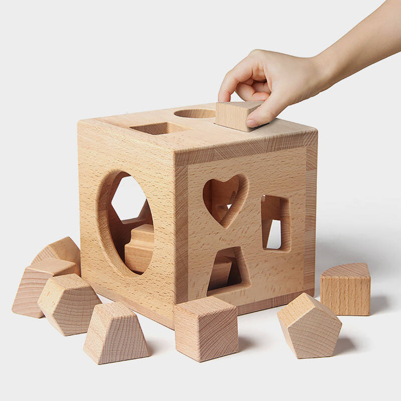 A simple wooden stacking toy next to a complex plastic toy with lights and sounds.