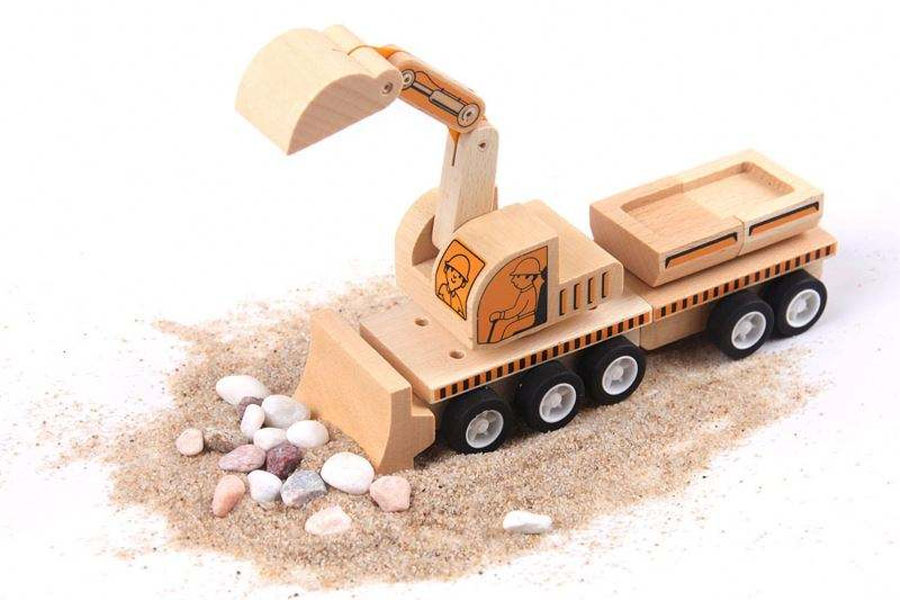 A child carefully placing small wooden blocks into the back of a dump truck.