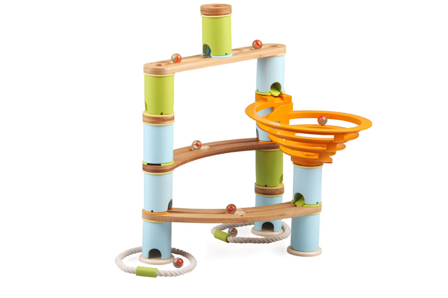 A child's hands adjusting a block on a wooden marble run to fix a problem.
