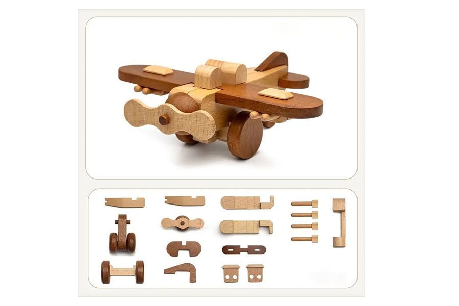 A classic wooden toy airplane with a spinning propeller, sitting on a wooden surface.