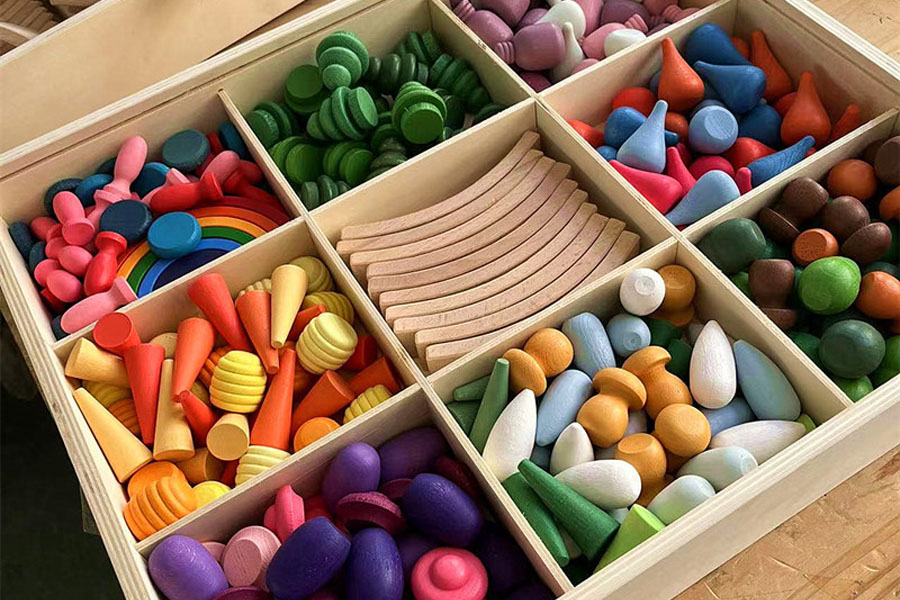 A single wooden rainbow stacker shown being used in three ways by children of different ages.
