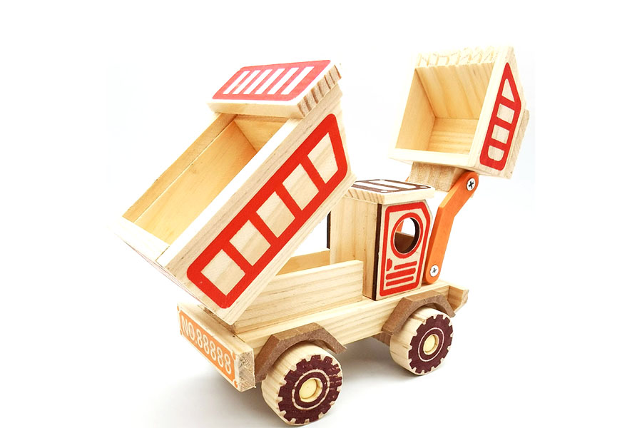 A solid wooden truck contrasted with a broken plastic truck to show durability
