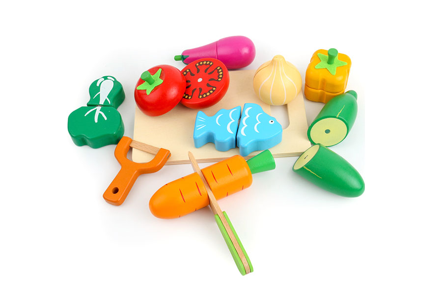 A variety of wooden food toys, including a cuttable loaf of bread, whole fruit, and a carton of milk