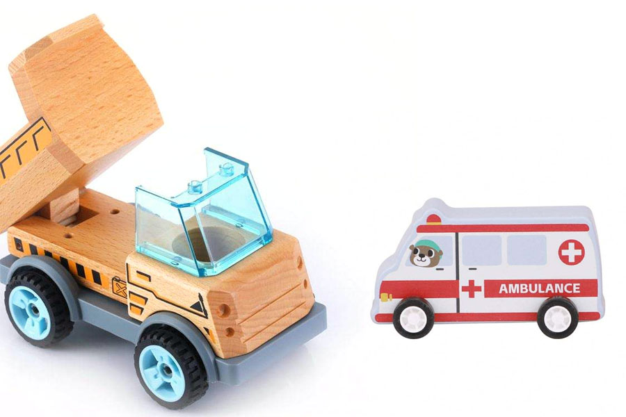 A wooden fire truck and dump truck being used together in a pretend construction scene with blocks