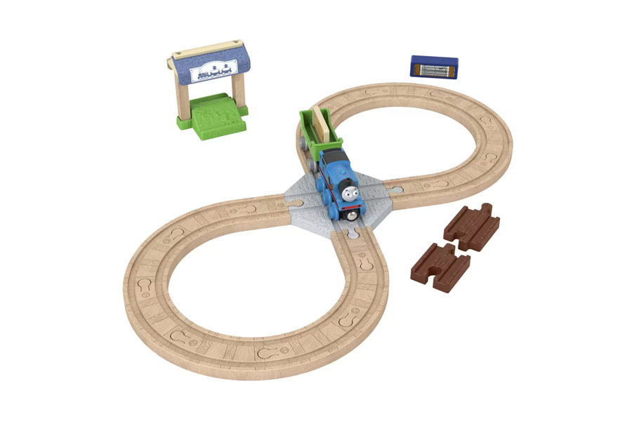 An adult's hand placing a rare, collectible Thomas engine on a display shelf.