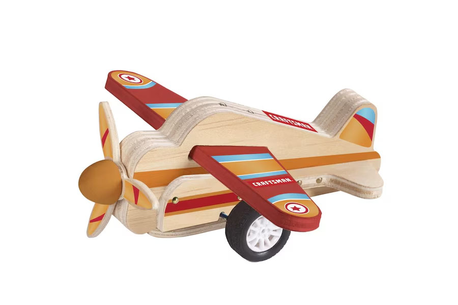 An older child has placed a wooden plane on a bookshelf as a decoration, showing its lasting appeal